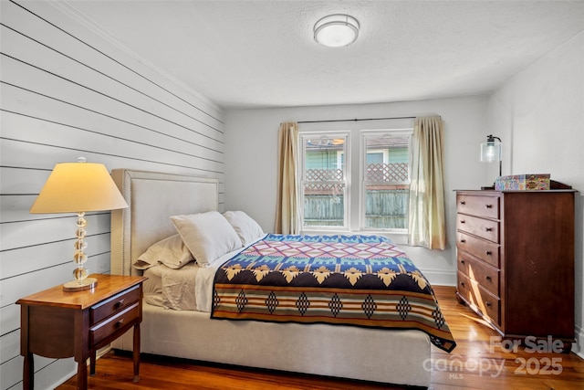 bedroom with a textured ceiling and wood finished floors