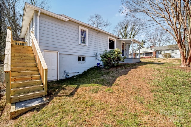 back of property with stairs, a porch, and a lawn