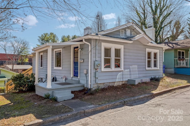 bungalow-style home featuring a chimney