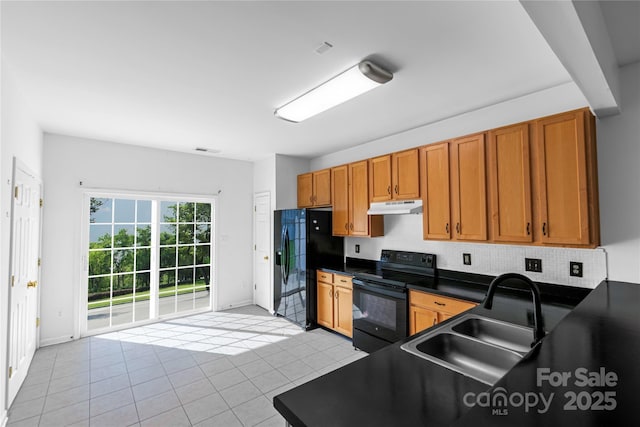 kitchen with visible vents, black appliances, under cabinet range hood, a sink, and dark countertops