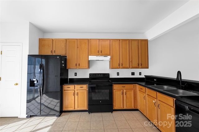 kitchen with light tile patterned flooring, a sink, black appliances, under cabinet range hood, and dark countertops