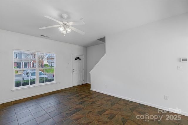 interior space with visible vents, stone finish floor, a ceiling fan, and baseboards