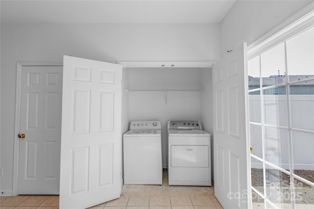 washroom with light tile patterned floors, laundry area, and washing machine and clothes dryer