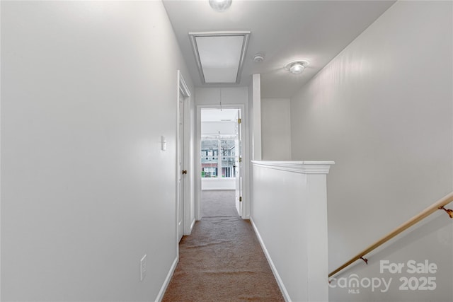 corridor featuring an upstairs landing, baseboards, attic access, and carpet