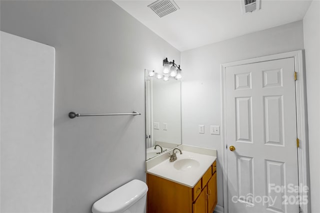 bathroom featuring visible vents, toilet, and vanity