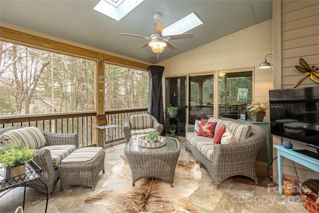 sunroom / solarium featuring lofted ceiling with skylight and a ceiling fan