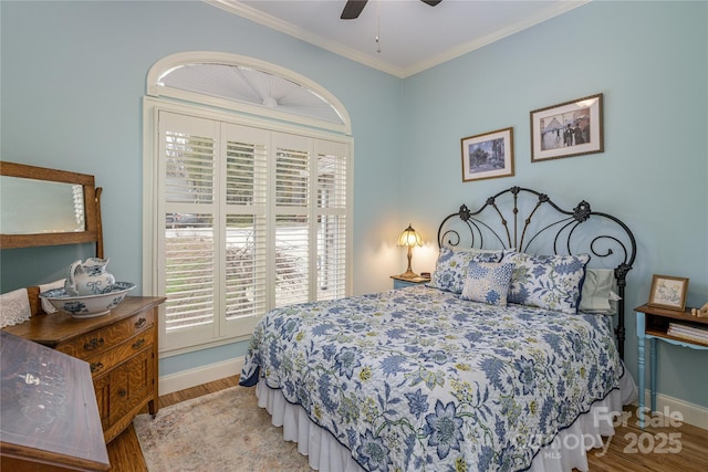 bedroom featuring a ceiling fan, crown molding, baseboards, and wood finished floors