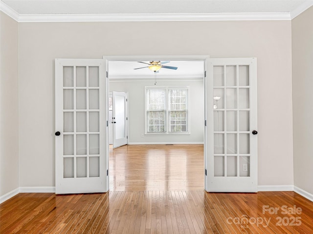 interior space with ceiling fan, baseboards, hardwood / wood-style floors, and ornamental molding