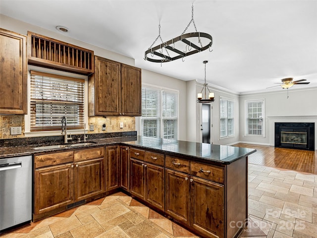 kitchen with stone tile flooring, a sink, tasteful backsplash, and stainless steel dishwasher