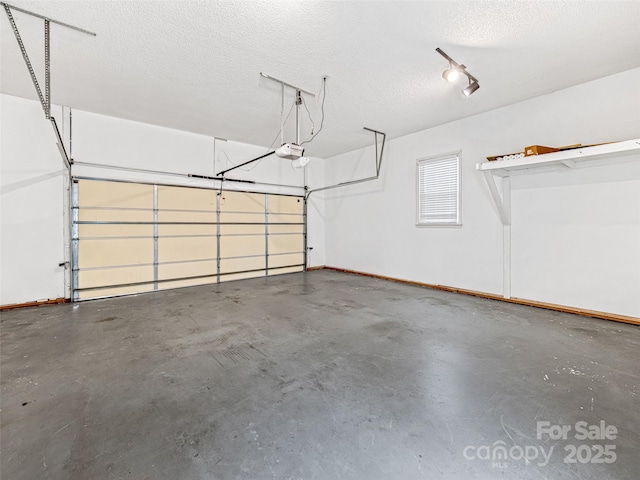 garage with a garage door opener and baseboards