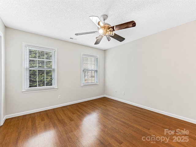 unfurnished room featuring baseboards, a textured ceiling, and wood finished floors