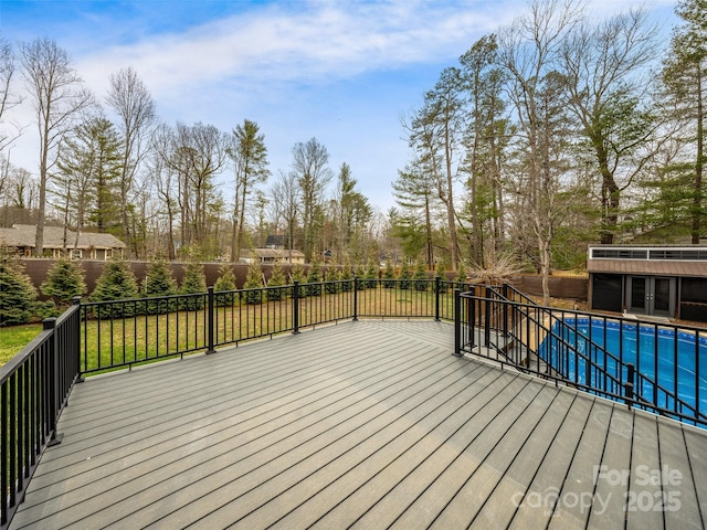 wooden deck with an outdoor structure, a fenced in pool, and an exterior structure