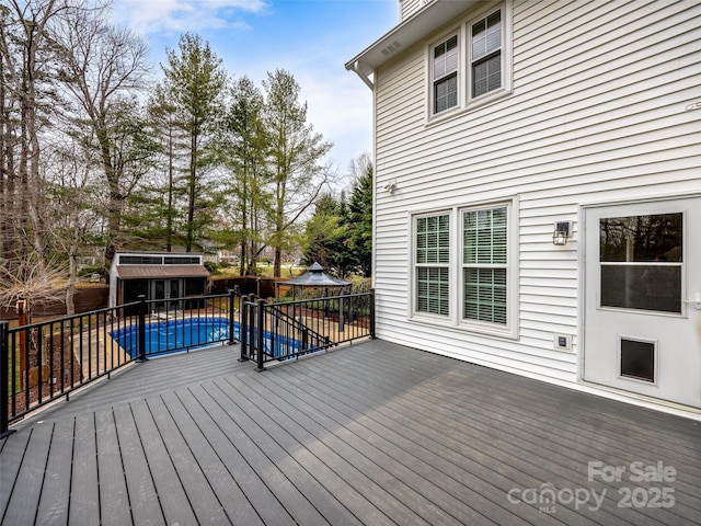 wooden deck with a gazebo, a fenced in pool, and fence