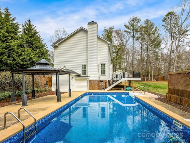 view of pool with a deck, a gazebo, a fenced in pool, stairs, and a patio area