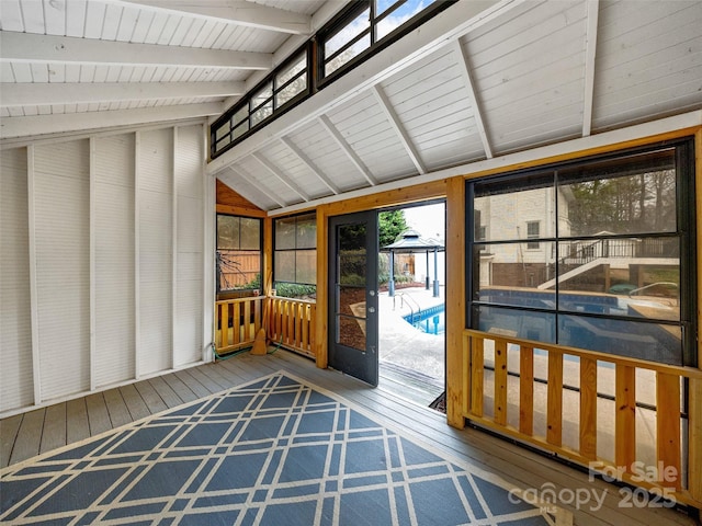 unfurnished sunroom with vaulted ceiling with beams