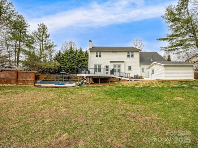 back of property featuring a fenced in pool, fence, a chimney, a yard, and a deck