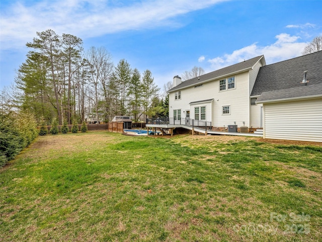 rear view of house featuring fence, a wooden deck, cooling unit, a chimney, and a yard