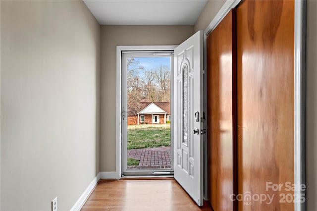 entryway with light wood-style flooring and baseboards