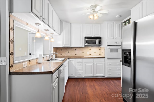 kitchen with appliances with stainless steel finishes, white cabinetry, a ceiling fan, and a sink