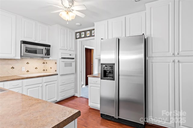 kitchen featuring dark wood finished floors, appliances with stainless steel finishes, white cabinetry, and a ceiling fan