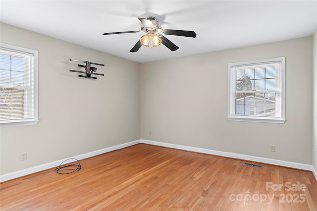 unfurnished room featuring visible vents, baseboards, a ceiling fan, and light wood finished floors