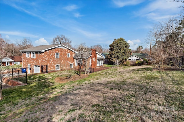 view of yard with an attached garage and fence