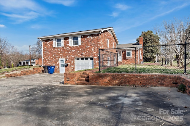 view of side of property featuring fence, brick siding, driveway, and a chimney