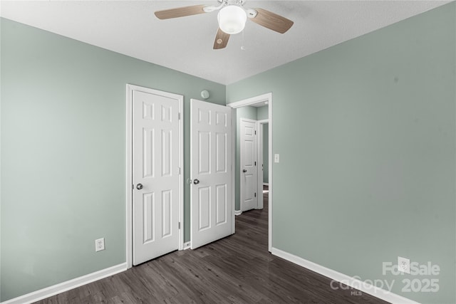 8421 Kings Creek Dr, Charlotte, NC 28273 - unfurnished bedroom featuring dark wood-style floors, a closet, baseboards, and a ceiling fan