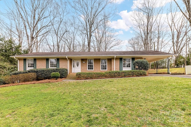 ranch-style house with brick siding, an attached carport, concrete driveway, and a front lawn