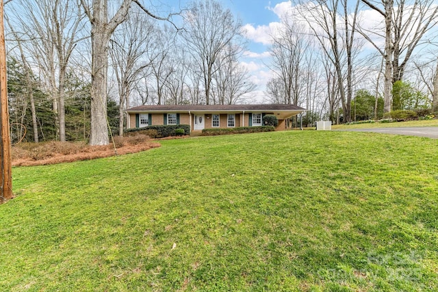 single story home featuring brick siding, a front yard, and driveway