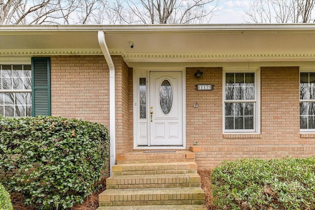 property entrance featuring brick siding