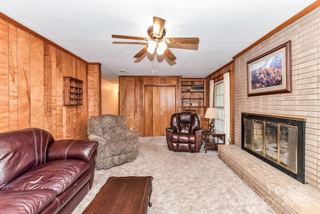 living room featuring a ceiling fan, built in features, a textured ceiling, wooden walls, and carpet flooring