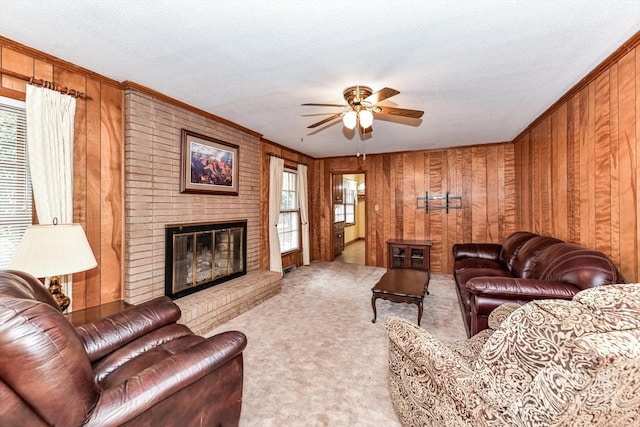 carpeted living area featuring wooden walls, a brick fireplace, a textured ceiling, and ceiling fan