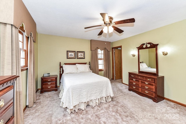 carpeted bedroom with ceiling fan and baseboards