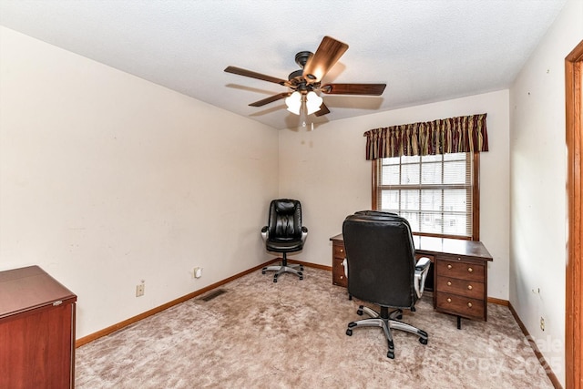 home office featuring visible vents, a ceiling fan, baseboards, and light carpet