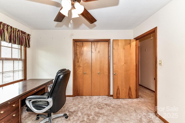 office with a textured ceiling, light colored carpet, baseboards, and ceiling fan