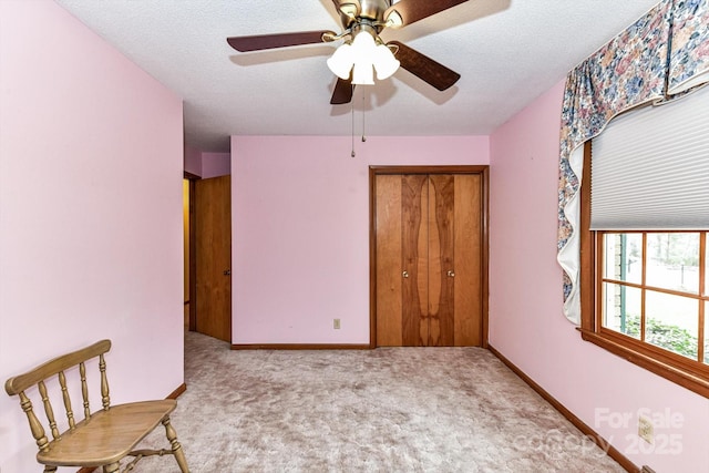 carpeted bedroom featuring a closet, ceiling fan, a textured ceiling, and baseboards