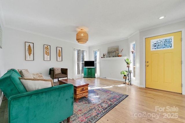 living area featuring recessed lighting, baseboards, wood finished floors, and crown molding