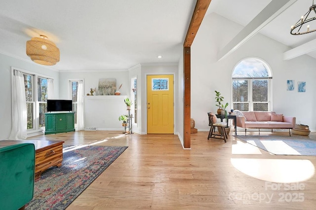 entryway featuring a chandelier, light wood-style flooring, baseboards, and a healthy amount of sunlight