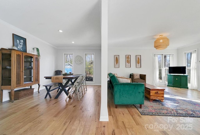 dining room featuring baseboards, crown molding, and light wood-style floors