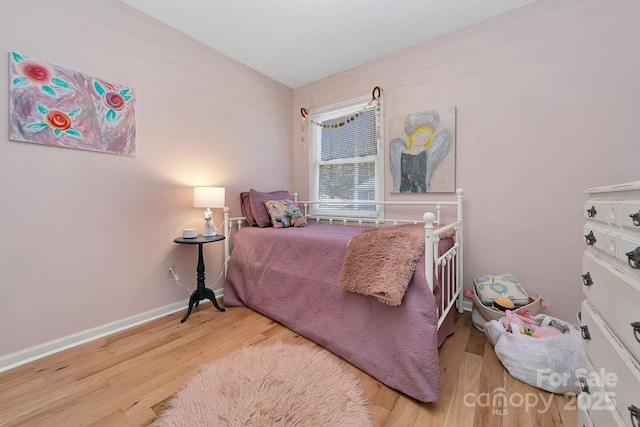 bedroom featuring baseboards and wood finished floors