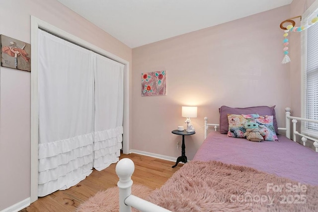 bedroom featuring a closet, baseboards, and wood finished floors