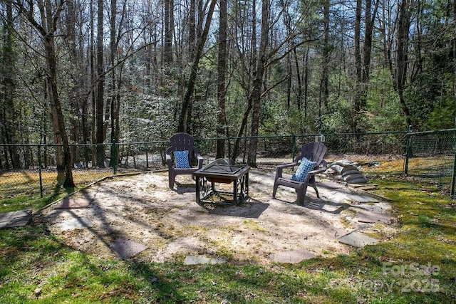 view of yard featuring a patio area, a fire pit, and fence