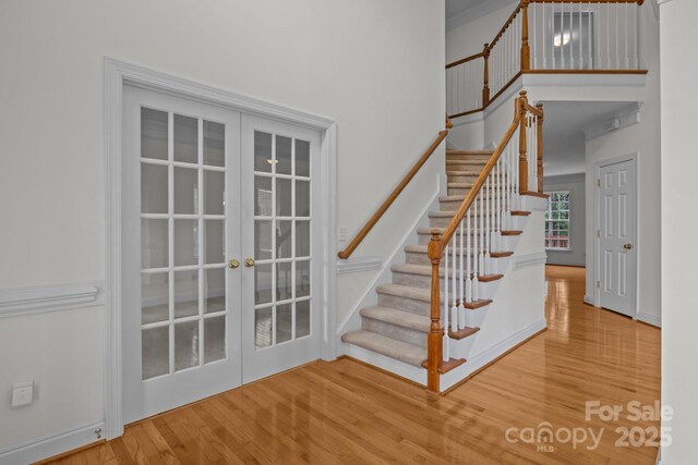 561 Keystone Ct NW, Concord, NC 28027 - stairway with french doors, wood finished floors, and a towering ceiling