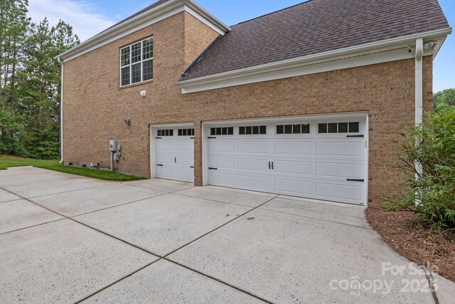 561 Keystone Ct NW, Concord, NC 28027 - view of property exterior with concrete driveway, a shingled roof, brick siding, and a garage