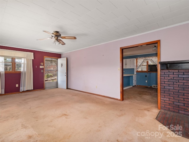 unfurnished living room with baseboards, carpet, a ceiling fan, and ornamental molding