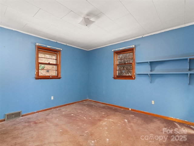 spare room with visible vents, baseboards, carpet, and ornamental molding