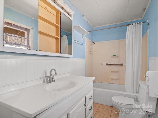 full bath featuring a wainscoted wall, toilet, tile patterned floors, shower / bath combination with curtain, and vanity