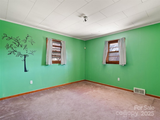 carpeted empty room with visible vents and baseboards