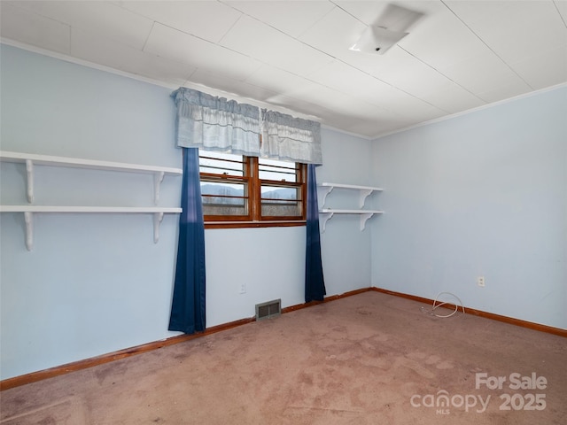 unfurnished room featuring visible vents, ornamental molding, baseboards, and carpet floors